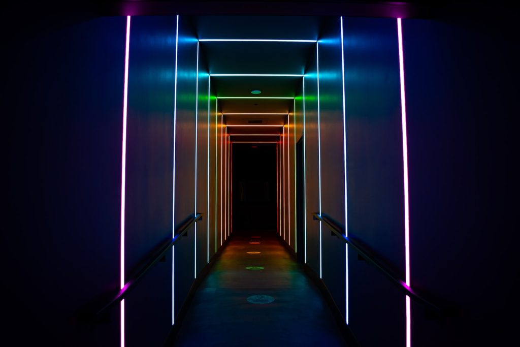 a long hallway with neon lights on the walls
