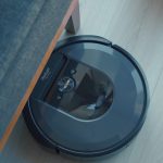 a robotic vacuum is on the floor next to a couch